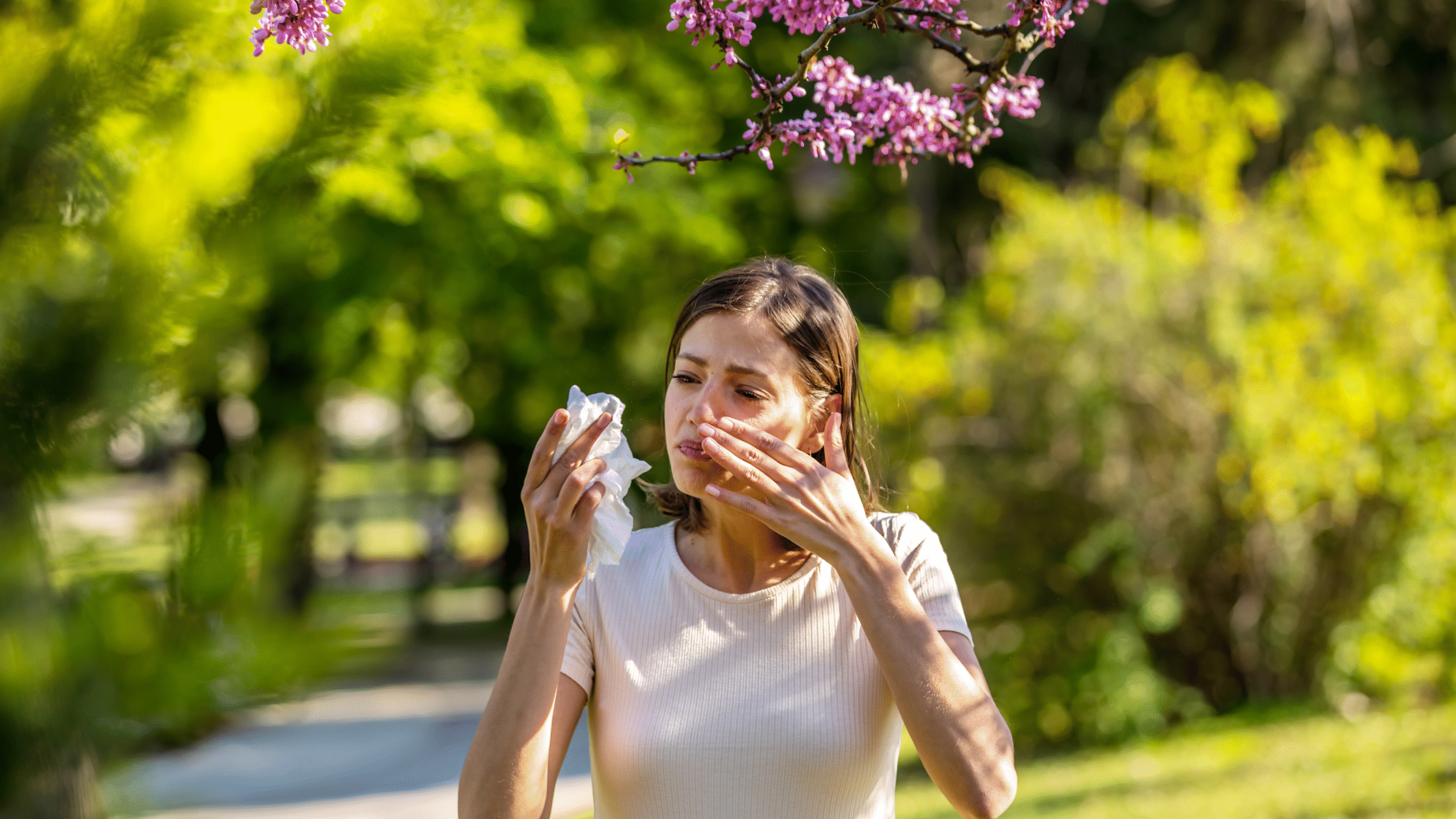 lady with sever springtime allergies outside with crying eyes and running nose