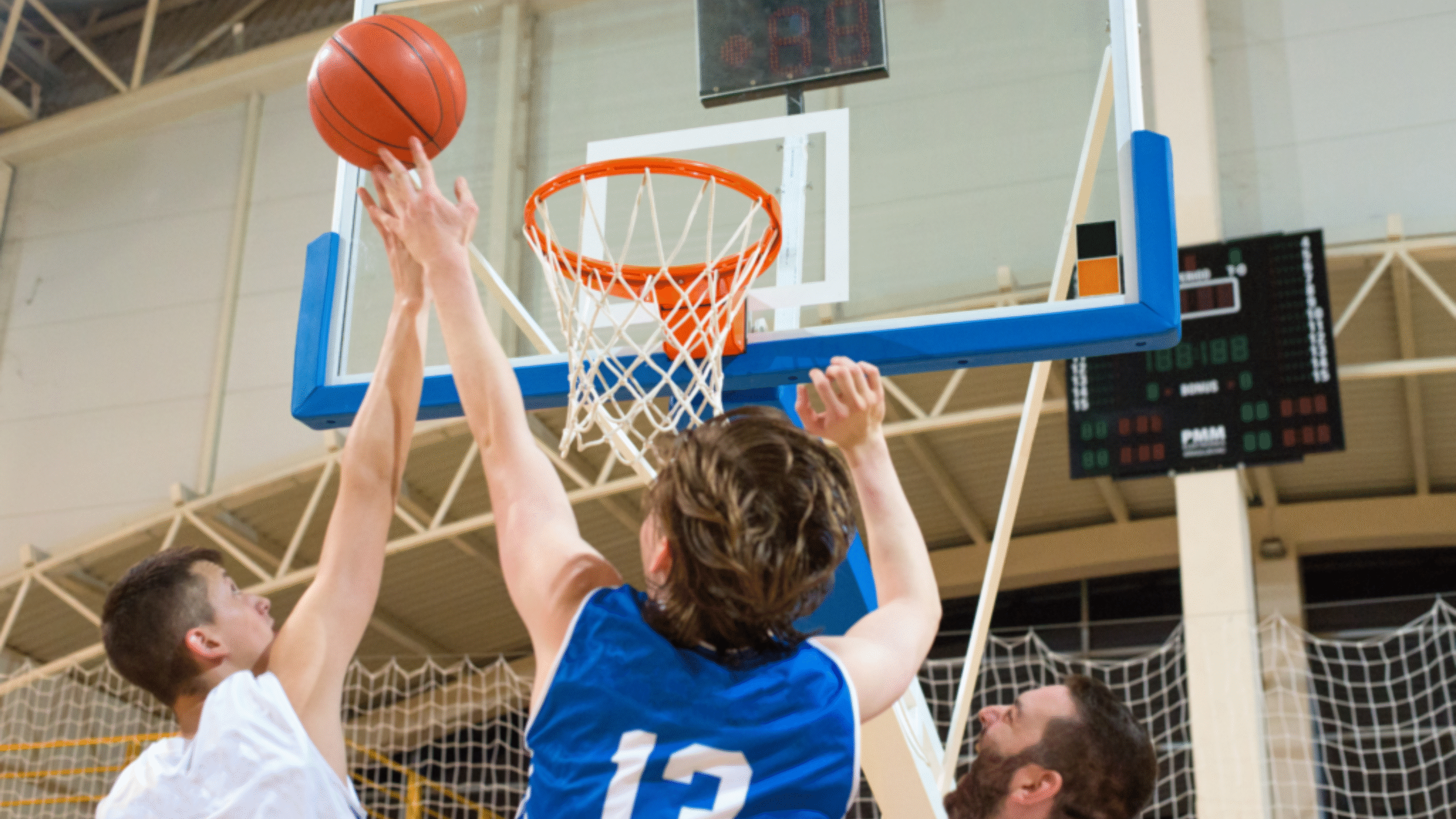 boy shots basketball into the hoop during game