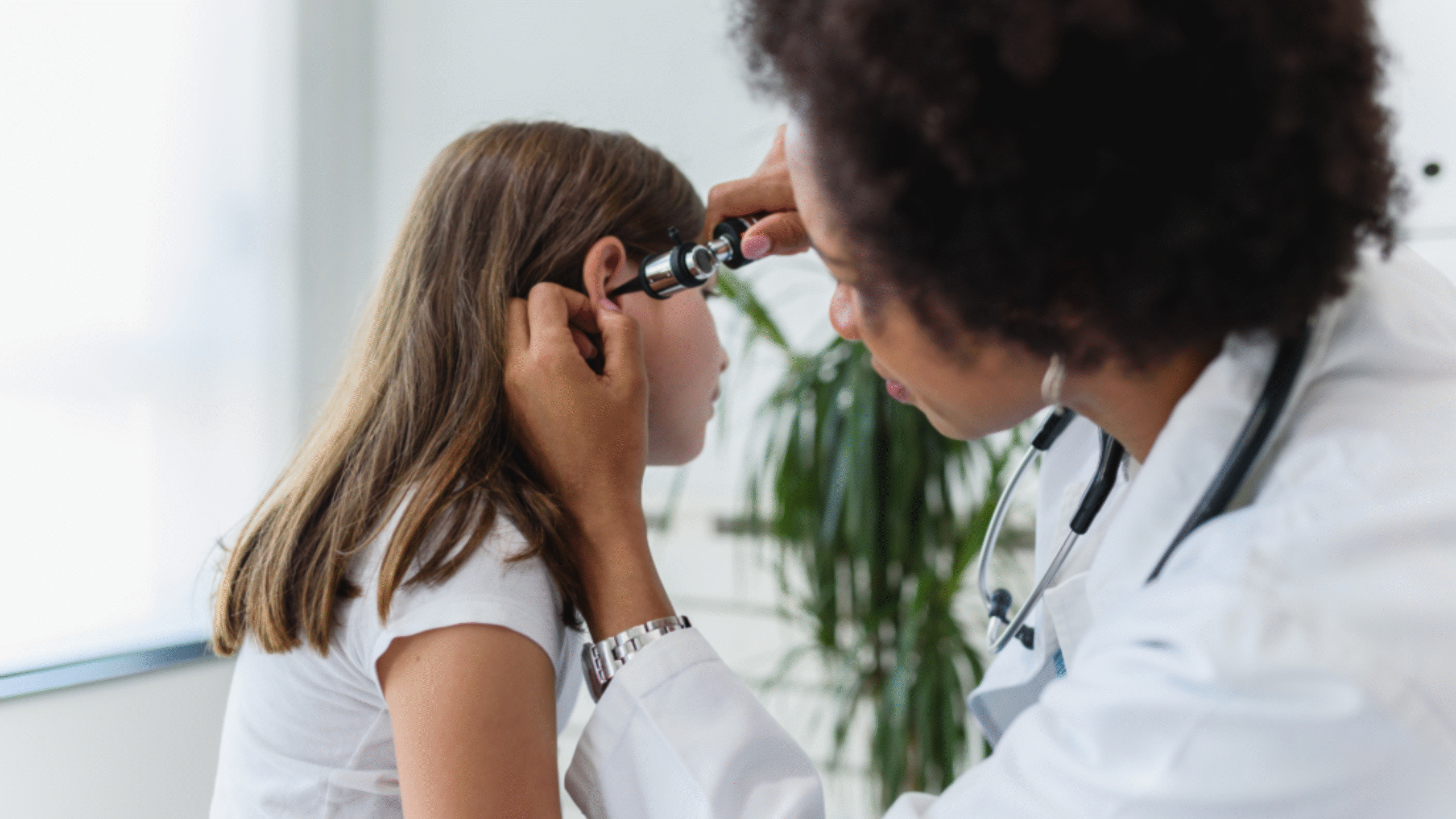 doctor looks in pediatric patient's ear