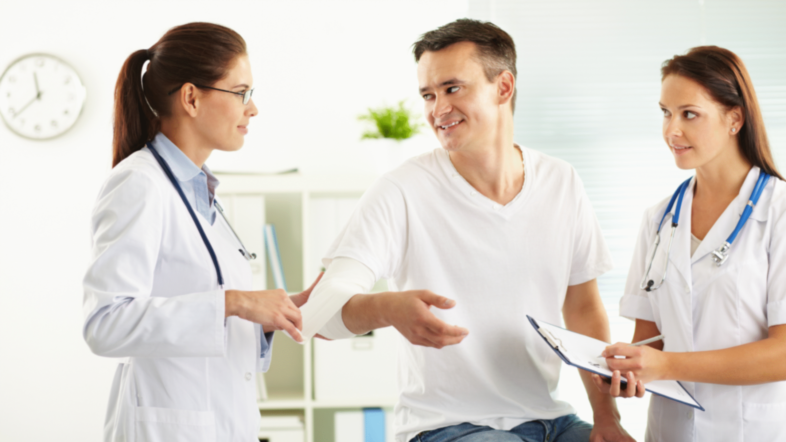 Doctor and nurse check out patients wound on his arm
