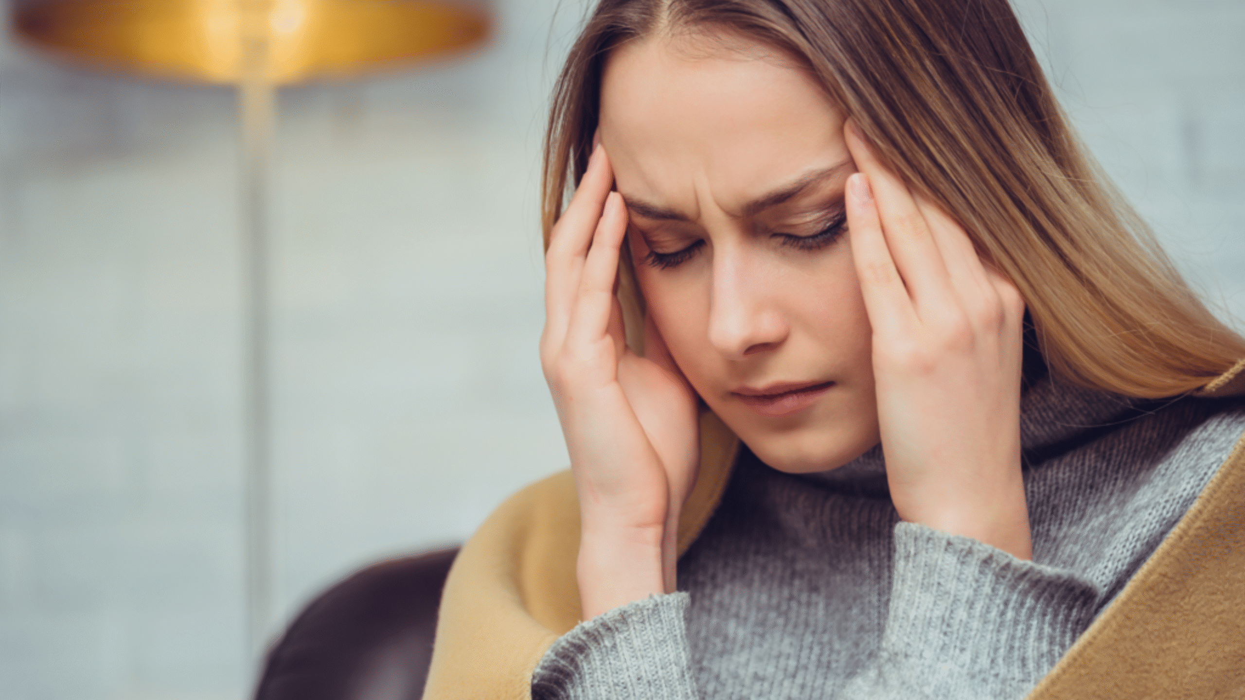 lady with extreme headache rubs temples