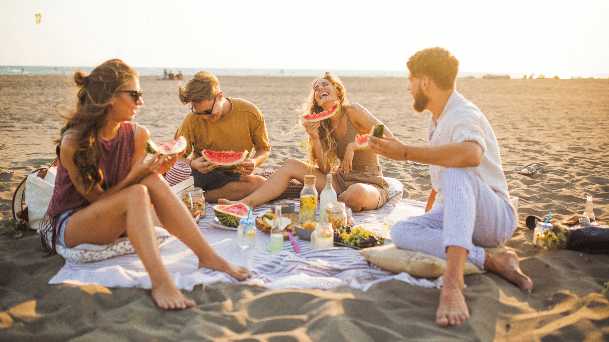 friends eating on the beach enjoying