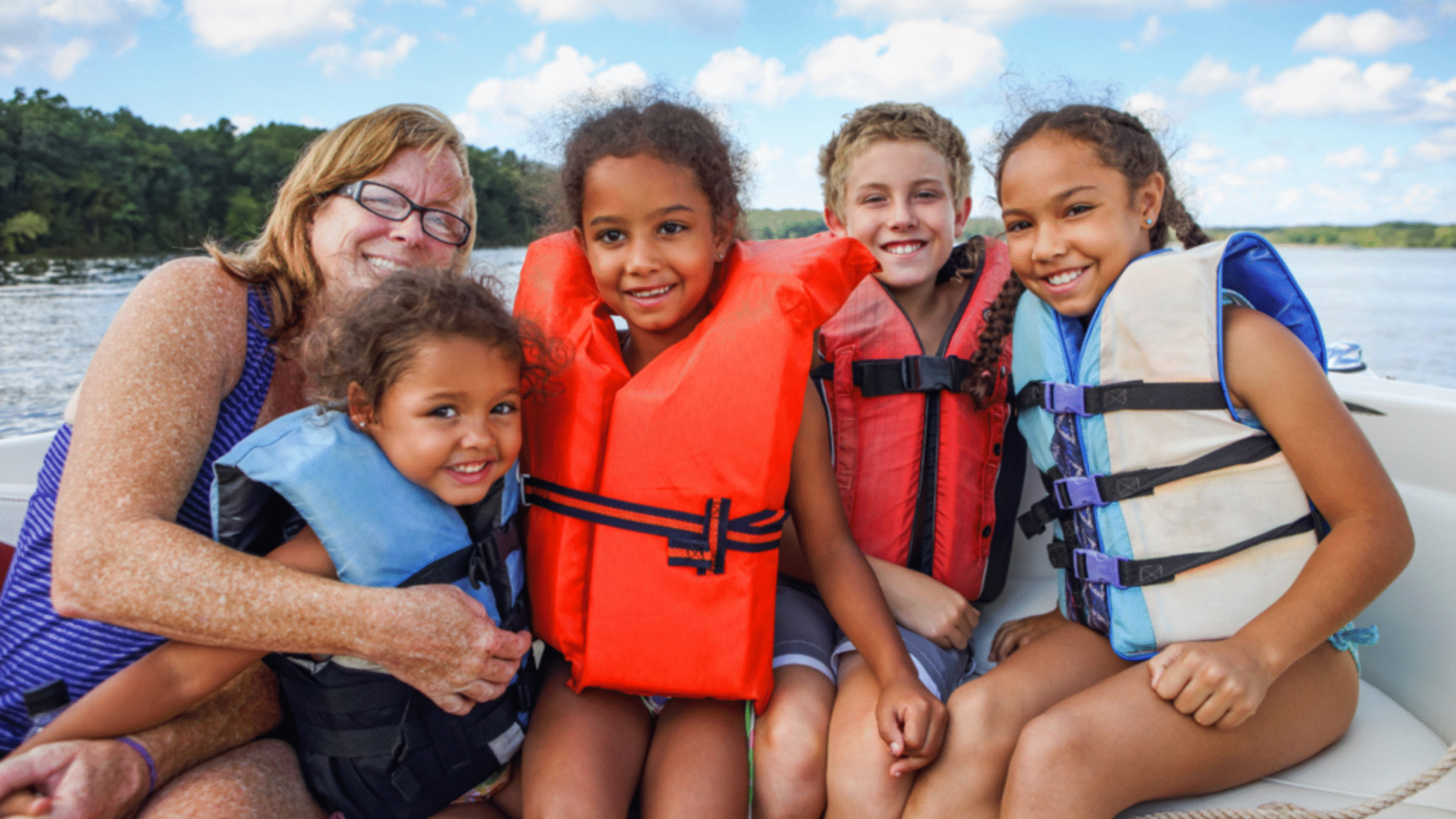 family practices water safety with life vest on at the lake
