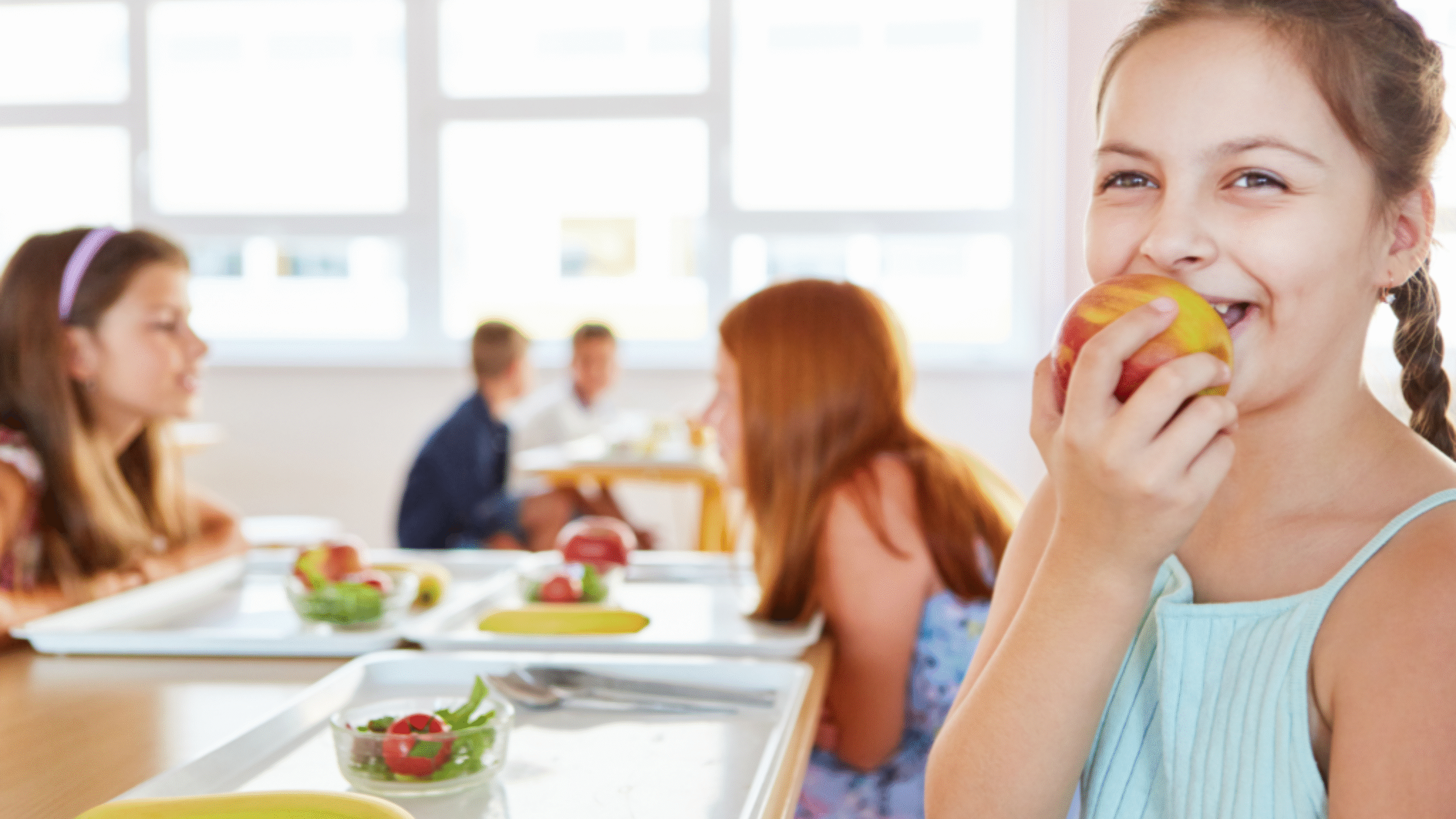 child eats an apple at lunch