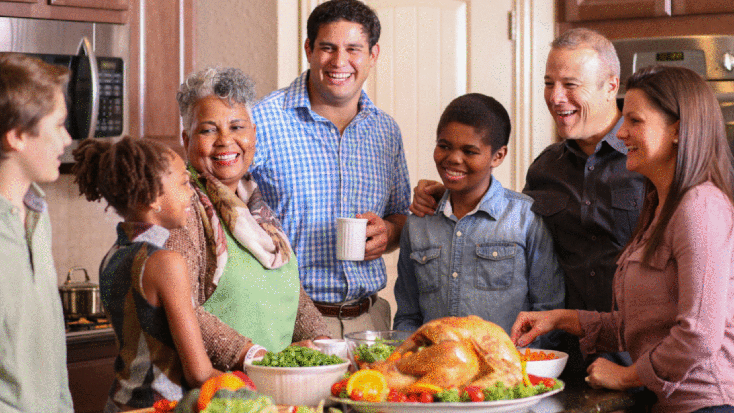 Family full of smiles around Thanksgiving turkey