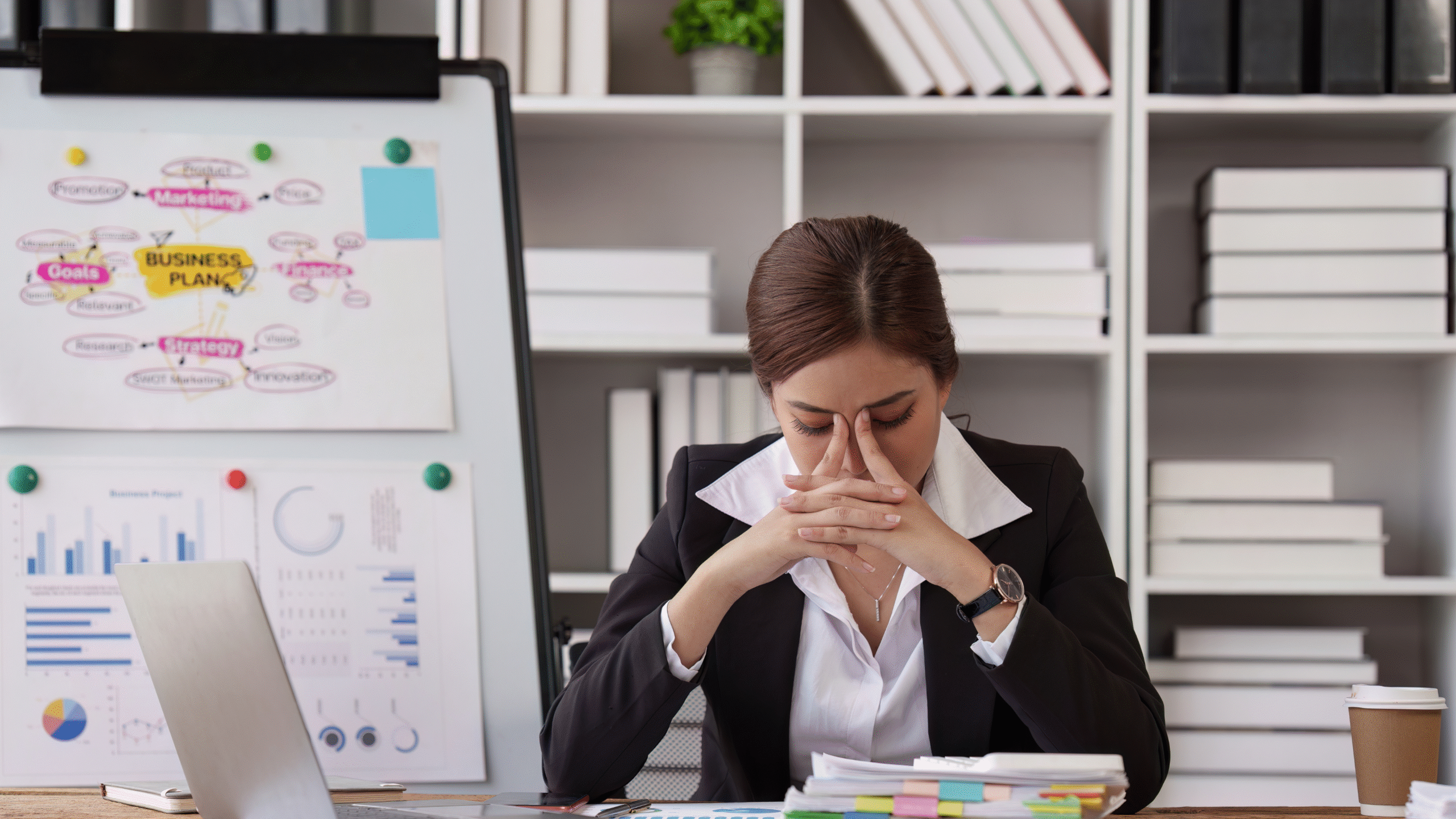 lady stressed at work desk with hands on face