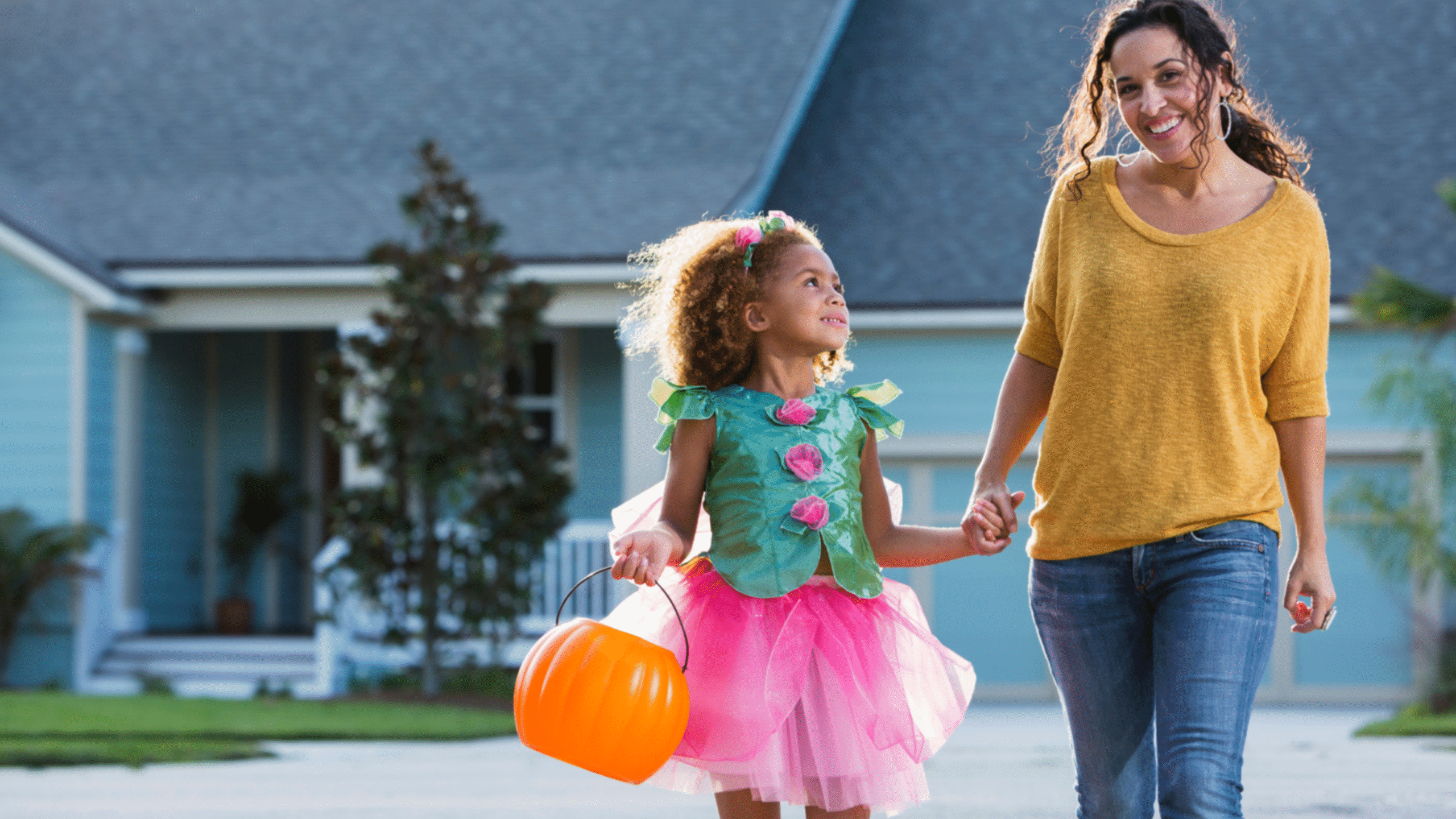 mom taking her daughter out to trick or treat on Halloween