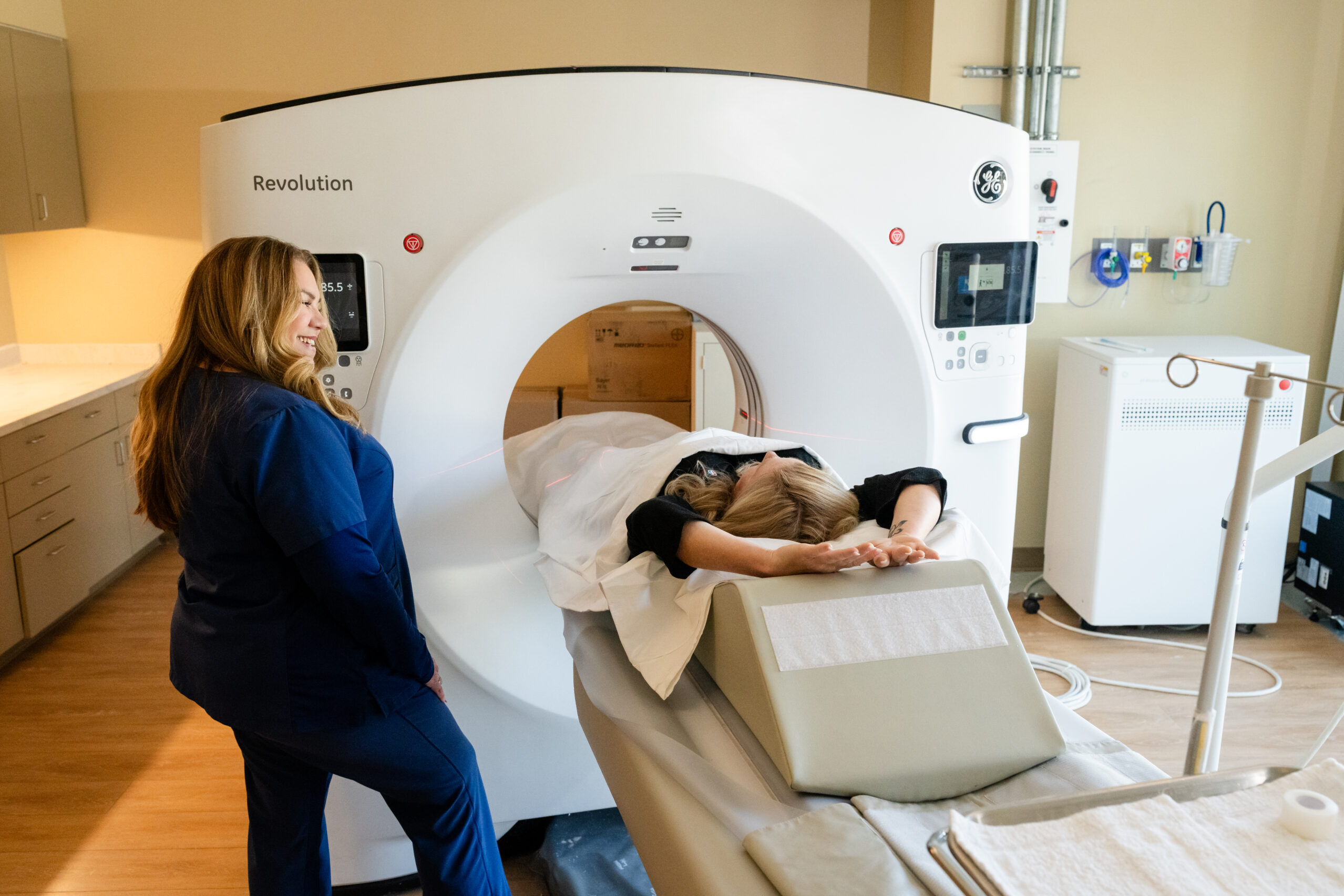 A medical professional helping a patient in an MRI machine.