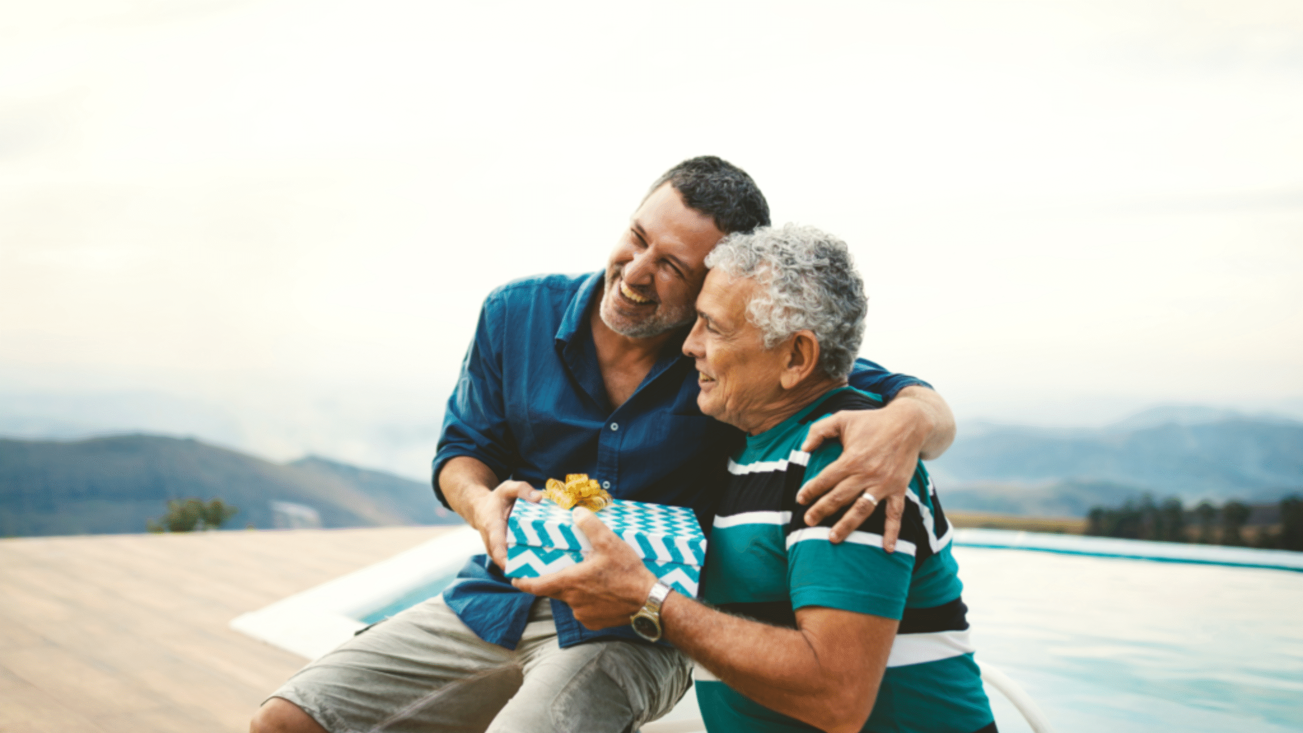 man gifts father a present on the beach