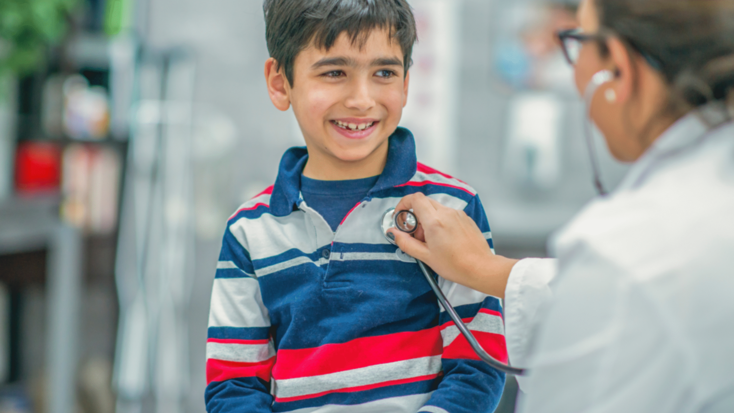 Doctor listens to young boy's heart